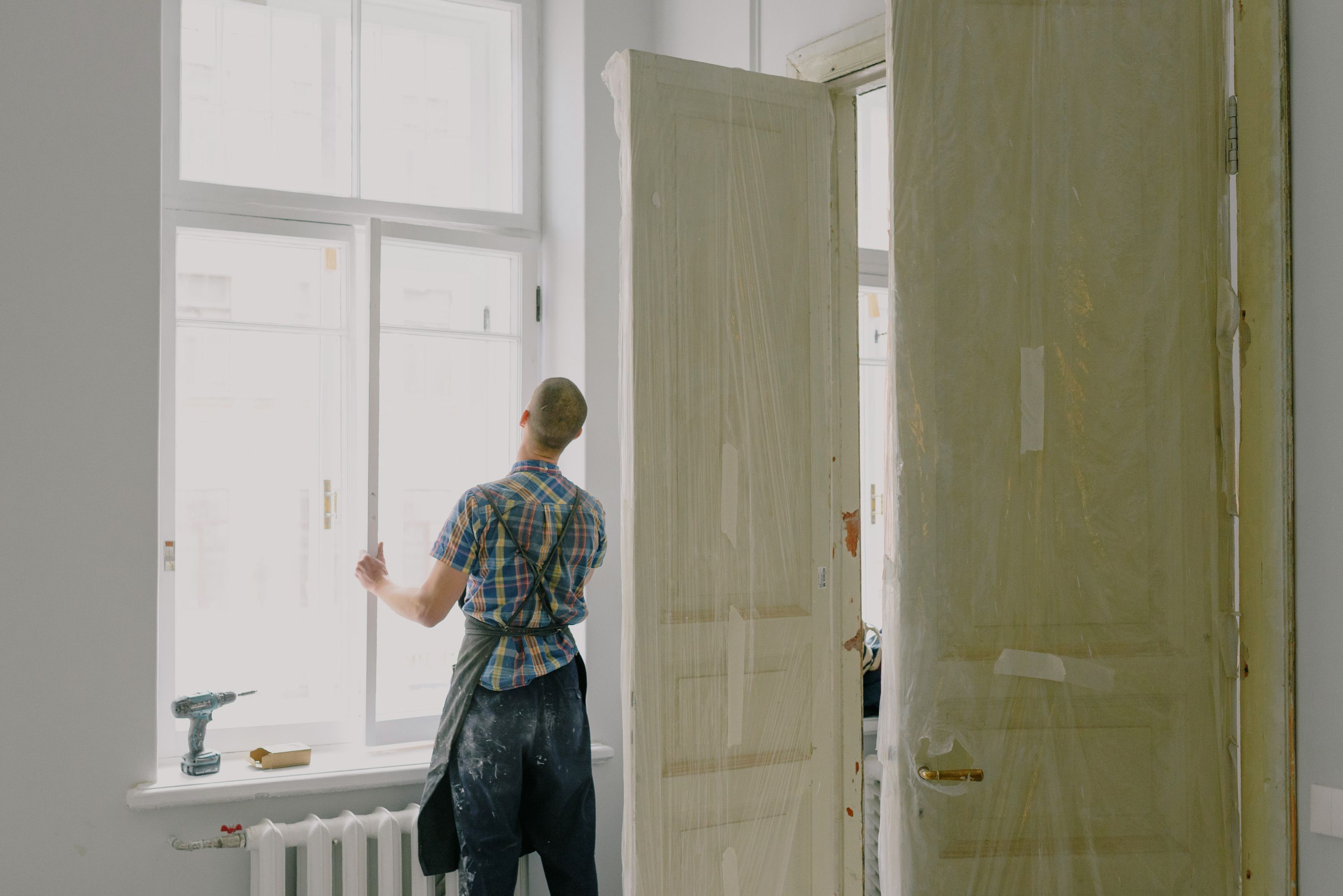Handwerker von Hausservice Rheinland repariert ein Fenster in hellem Raum